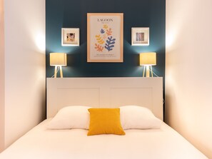 "Bedroom area with large double bed and duck blue wall"