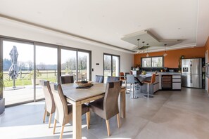 Wooden table, luxury chairs and view of terrace and garden