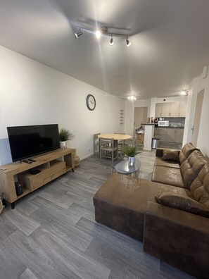"La Feuillette living room with TV stand, leather sofa, coffee table and dining table (different angle)"