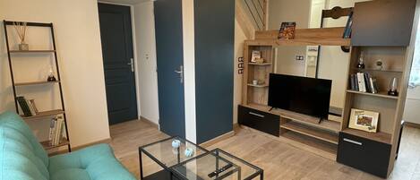 "Bright living room with green sofa and refined decoration".