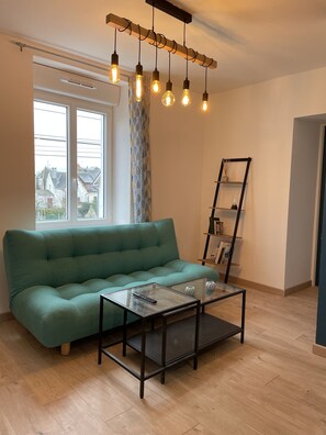 "Living room with sofa, window and bookshelf"