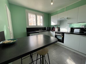 "Open Kitchen: Green Water Charm and Elegant Tiled Floor"