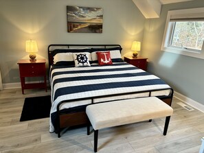 Upstairs bedroom with King bed,  two side tables, and bench.  Golf course view.