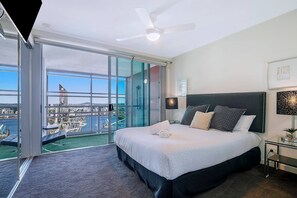 The master bedroom features a queen bed, mounted TV, and a ceiling fan to keep you comfortable plus an ensuite and balcony access.