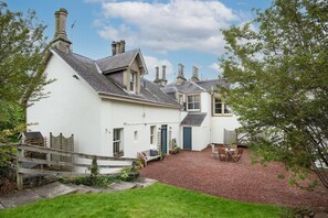 The Trouthouse - side aspect of the property with sloping lawned garden to the side