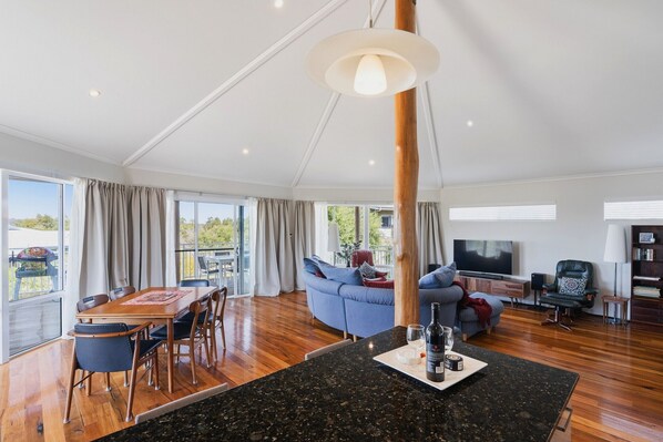 Come together in the sun-drenched living room beneath soaring timber ceilings.