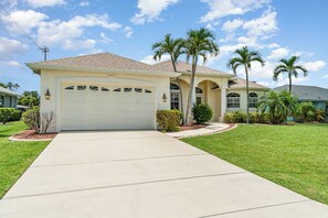 Charming vacation home with palm-tree-lined entryway, offering a welcoming Florida getaway.