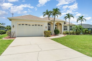Charming single-story home with lush landscaping and a spacious driveway, ideal for a peaceful family getaway.