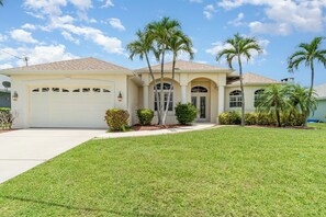 Charming vacation home with palm-tree-lined entryway, offering a welcoming Florida getaway.