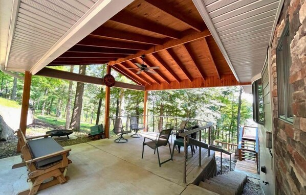Patio: Embrace the great outdoors from our spacious deck, featuring transparent cable railings that offer clear views of the natural stone landscaping and wooded scenery.
