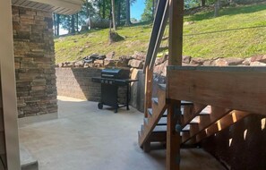 Get ready to grill and chill in our covered patio area, equipped with a modern BBQ grill set against a beautiful stone wall backdrop. It’s a great space for outdoor dining and enjoying the warm weather.