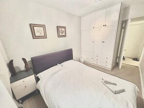 Double bedroom with large windows and built in wardrobes/drawers. 