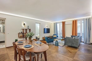 Salon avec canapé et télévision et table pour diner