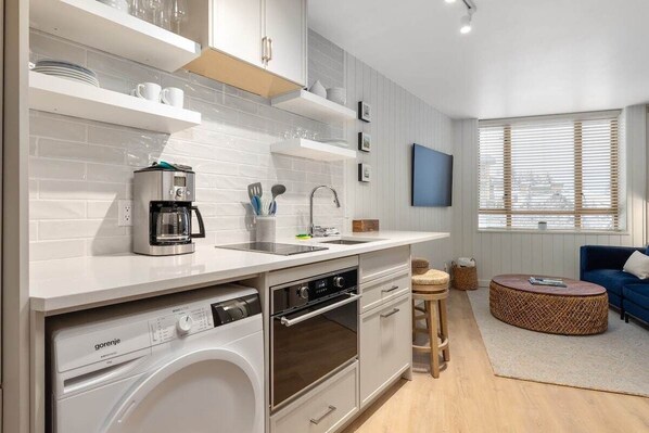 Kitchen includes a 2-burner induction cooktop, full fridge and freezer, dishwasher, and 'Speed Oven' (think of a combination between a microwave and oven).