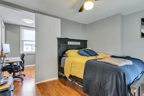 Unwind in the cozy bedroom featuring a queen bed with premium linens and ample storage space for your belongings. Large windows allow natural light to fill the room, creating a warm and inviting atmosphere.