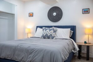 Welcome to Bedroom 2, with a queen bed, side lamps and side tables.