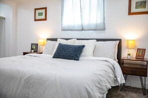 Bedroom with a king bed, side tables, and lamps.