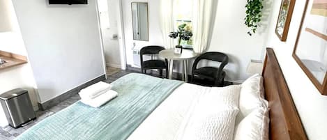 Lovely updated hotel style room with King Bed, dining table, Mini fridge, smart TV, Kitchenette and private bathroom.