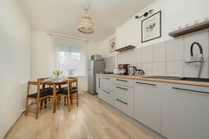 A stylish kitchen with white cabinets, a wooden countertop, and a dining table.