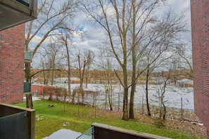 A scenic view of a serene river and lush trees, visible from the apartment's window, enhancing the tranquil ambiance.