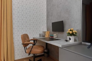 A stylish workspace featuring a desk with geometric wallpaper, a comfortable office chair, and decorative accents.