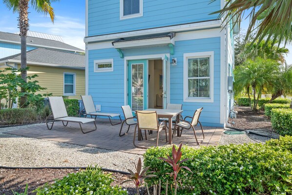 - Lush outdoor dining area of the townhouse in Kissimmee Florida - The outdoor dining and lounge chairs provide the perfect setting for al fresco dining and relaxation - Experience outdoor bliss with charming dining