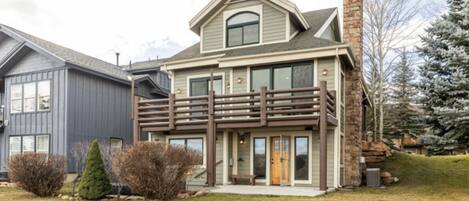 Back of home with trees surrounding the private sunken hot tub