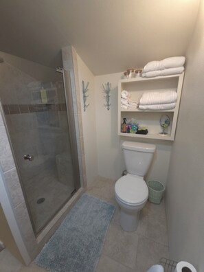 Tiled, walk in shower with corner seat. Roomy bathroom.