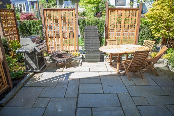 Outdoor patio with BBQ and water feature.