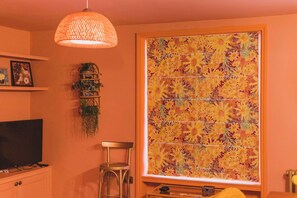 A stylish space with warm lighting, unique decor, and a colorful statement blind.