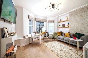 Step into our inviting living area, adorned with pristine white walls that exude a sense of modern elegance. Relax and unwind as you enjoy your favorite shows and movies on the sleek smart TV, providing a world of entertainment at your fingertips. 