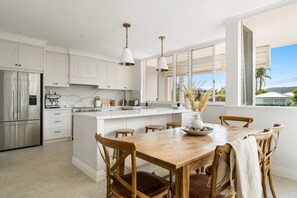 Dine together on the eight-seater natural wooden table setting or more casually on the bar stools by the kitchen.
