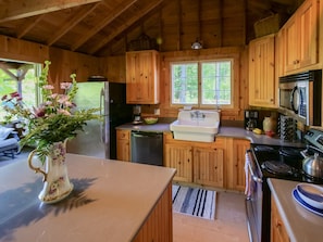 Open kitchen with large island and double french doors to screen porch w lake views