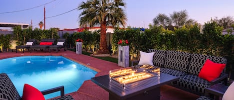 Outdoor patio with heated optional pool, hot tub, fire pit, outdoor dining area, BBQ, and cornhole.