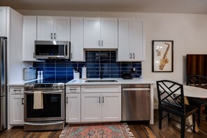 Step into a serene and modern kitchen space adorned with soothing blue cabinets and warm hardwood floors, creating a harmonious atmosphere that blends style and comfort seamlessly.