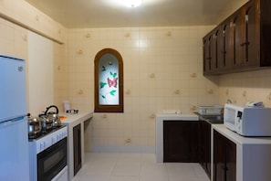 Kitchen equipped with microwave, refrigerator, stove, utensils, silverware, blender, coffee machine, amongst other add-ons. 