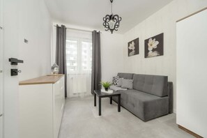 A small entryway with a gray sofa and minimalist design, leading into the living space.