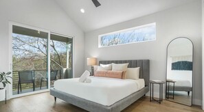 Primary bedroom with king bed, luxury linens, balcony, luxurious bathroom with walk in closet