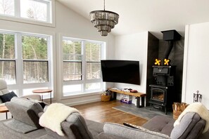 Living room, large TV, wood burning stove, board games.