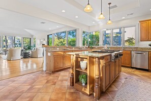 Large fully equipped open kitchen with 4 barstools and kitchen table that seats 6