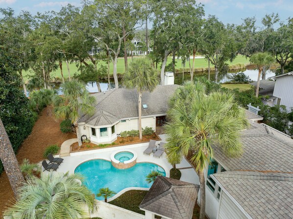 View of front of house with pool and spa; Lagoon and golf course can be seen in the backyard