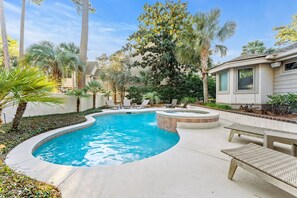 Private pool and spa in front yard of house with loungers