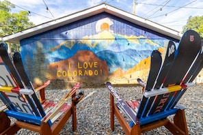 Custom mural, ski chairs, and string lights make for a great sitting area.