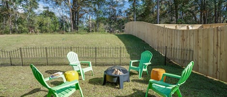 Patio for four with Adirondack chairs and fire-it in a large fenced lawn