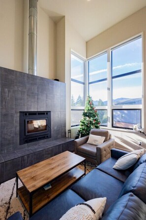 The living room has a wood burning fireplace and lots of natural light