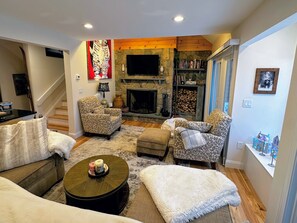 2nd level main living area with wood burning fireplace and TV