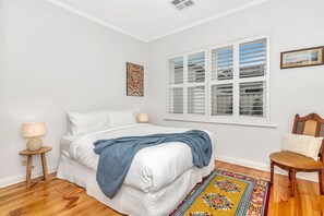 The second bedroom includes a queen-size bed with side tables and reading lamps. 
