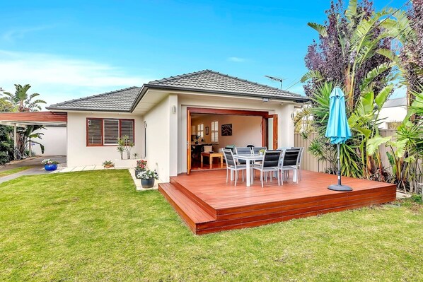 A generous outdoor space is ideal for relaxation and entertaining, complete with a furnished deck overlooking the front lawn and tropical gardens. 

