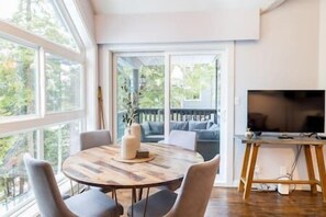 Sunny vibes in this well-lit living area, TV by the cozy sofa. Slide open the door to a balcony oasis with a BBQ and extra seating.