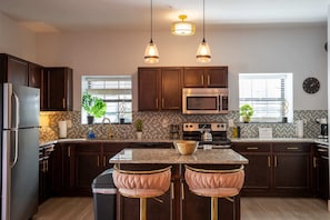 A modern kitchen is stocked with everything a person needs for a delicious home made meal.